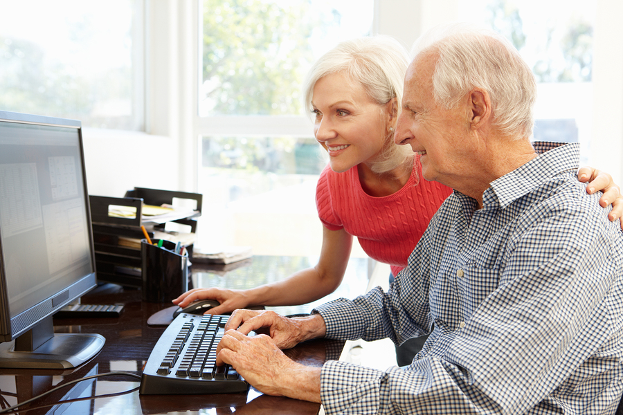 Senior man and daughter using computer at home