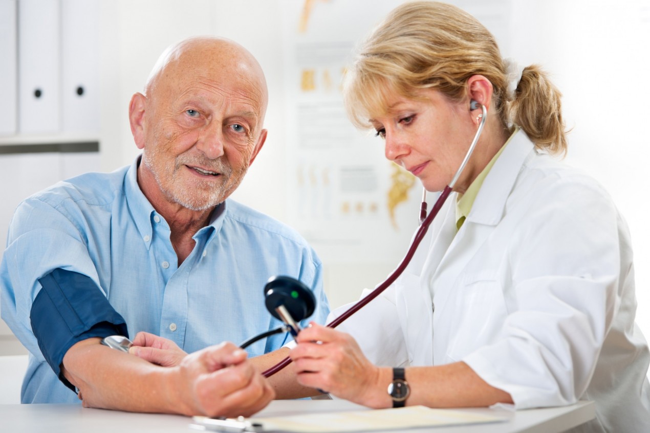 female doctor checking blood pressure of a senior man